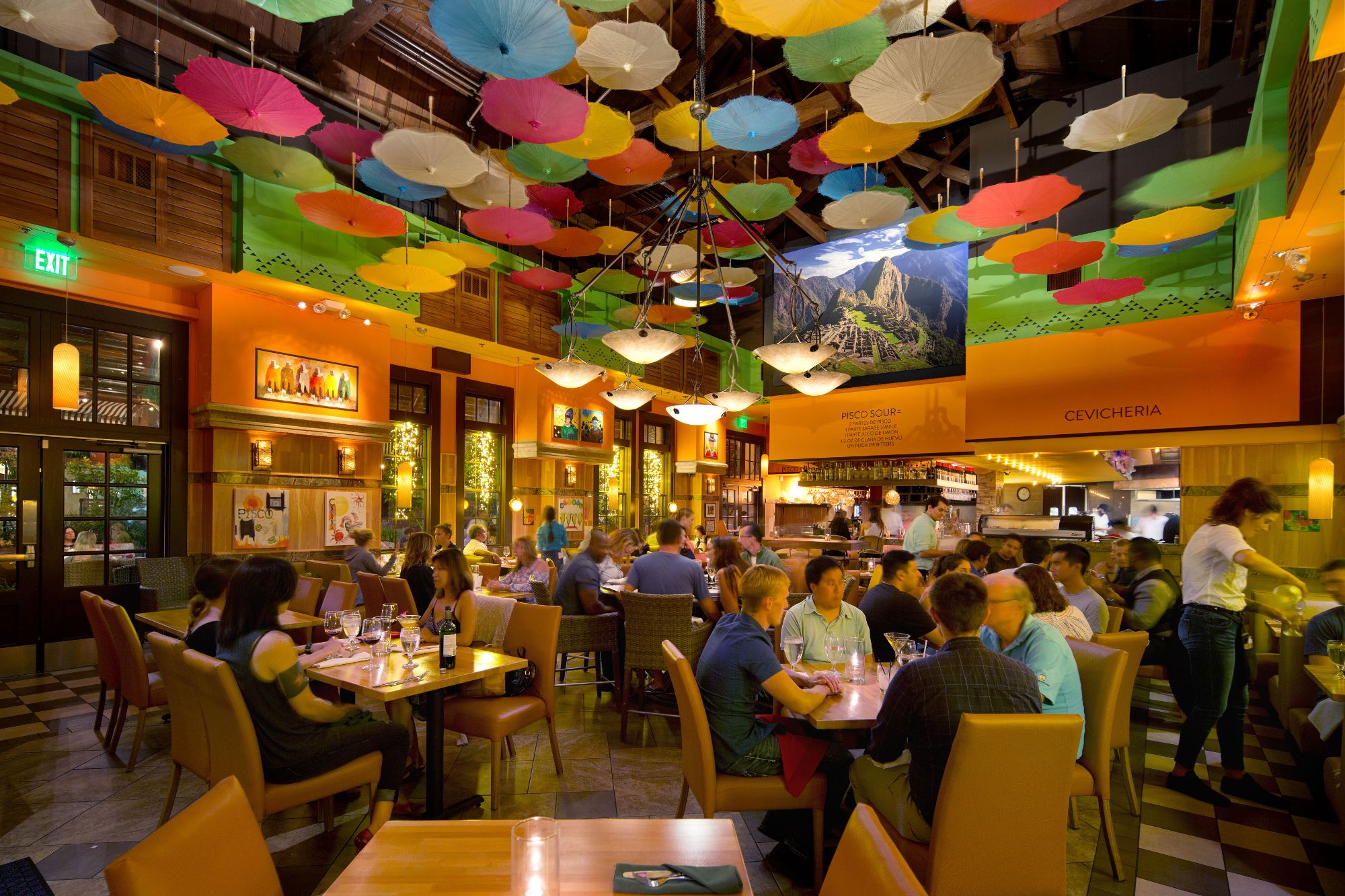 Guests dining beneath a canopy of colorful parasols in one of our restaurants